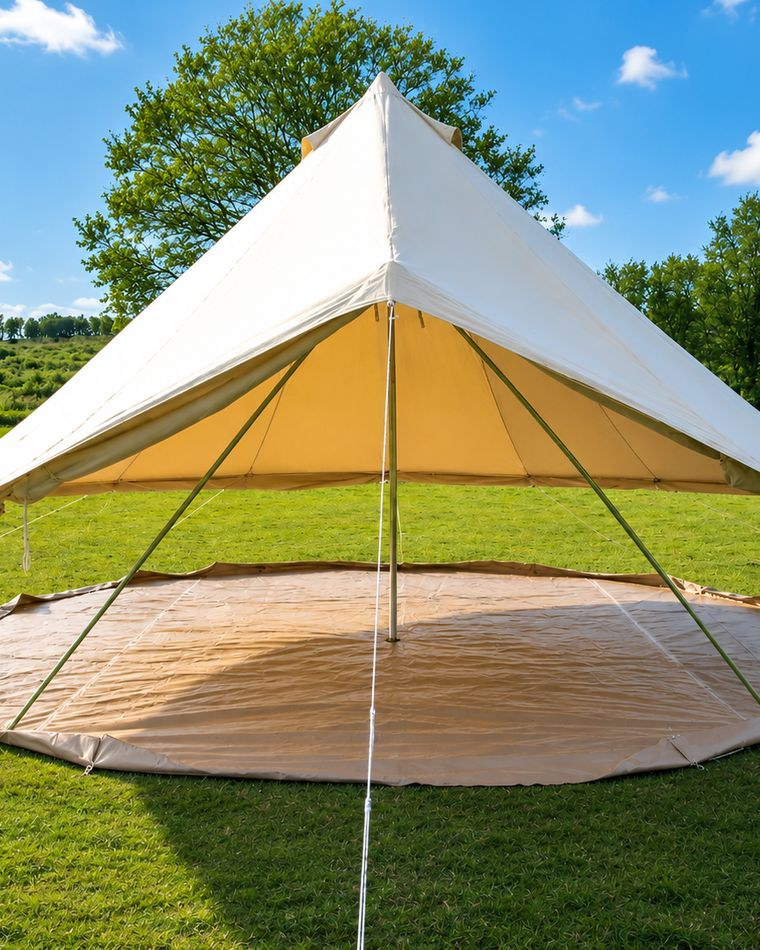 The bell tent in a field with the canvas walls rolled right up, showing the groundsheet and the shade underneath